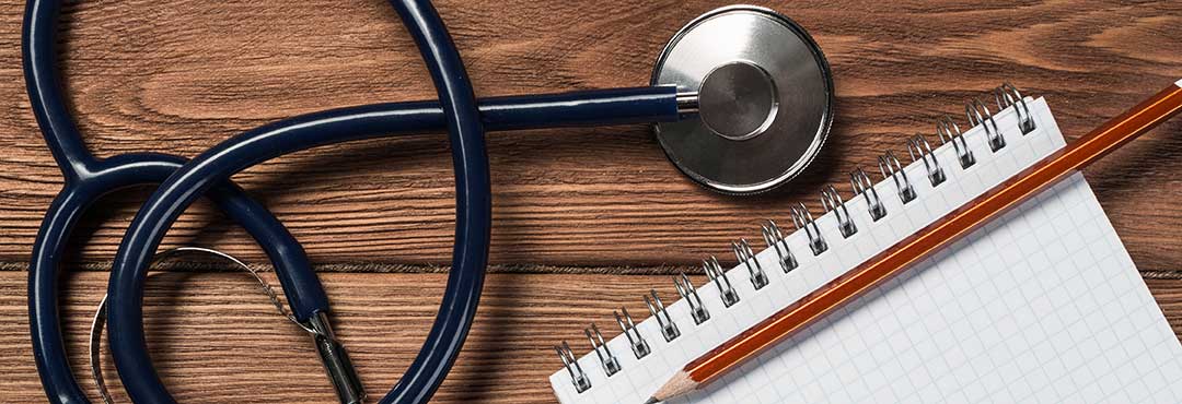 Stethoscope beside pen and paper to denote medical and professional standards that can also be presented evidence.