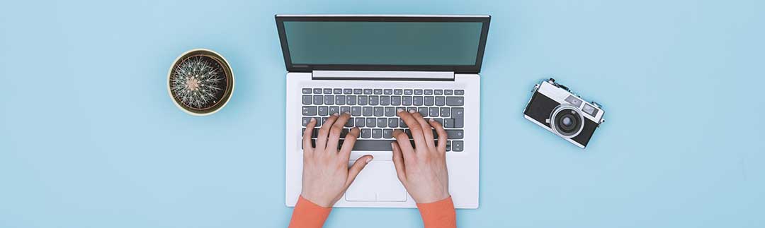 A lady writing on a computer as a mortgage is a written document.