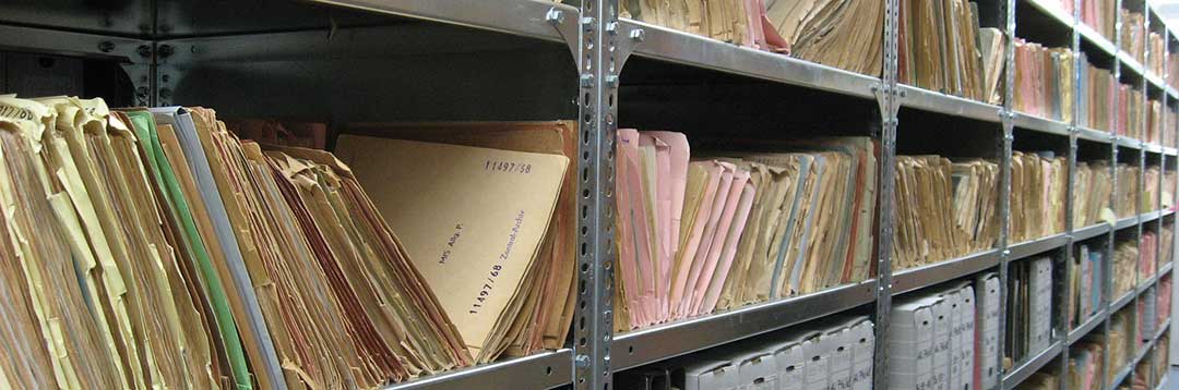 A long row of metal shelving racks with hundreds of cardboard files to illustrate the need for a thorough and complete inventory of the Conjugal Property.