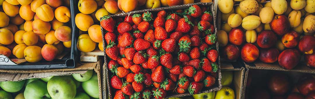 A photo of boxes of apples, oranges, lemons and strawberries at a grocery store as an example of family expenses to be borne by both Spouses after they have separated.
