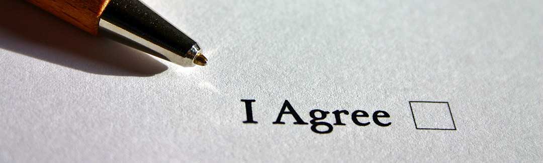 A white piece of paper with an "I agree" checkbox and a metal nibbed pen, symbolizing a Joint filing of a Judicial Separation of Property.