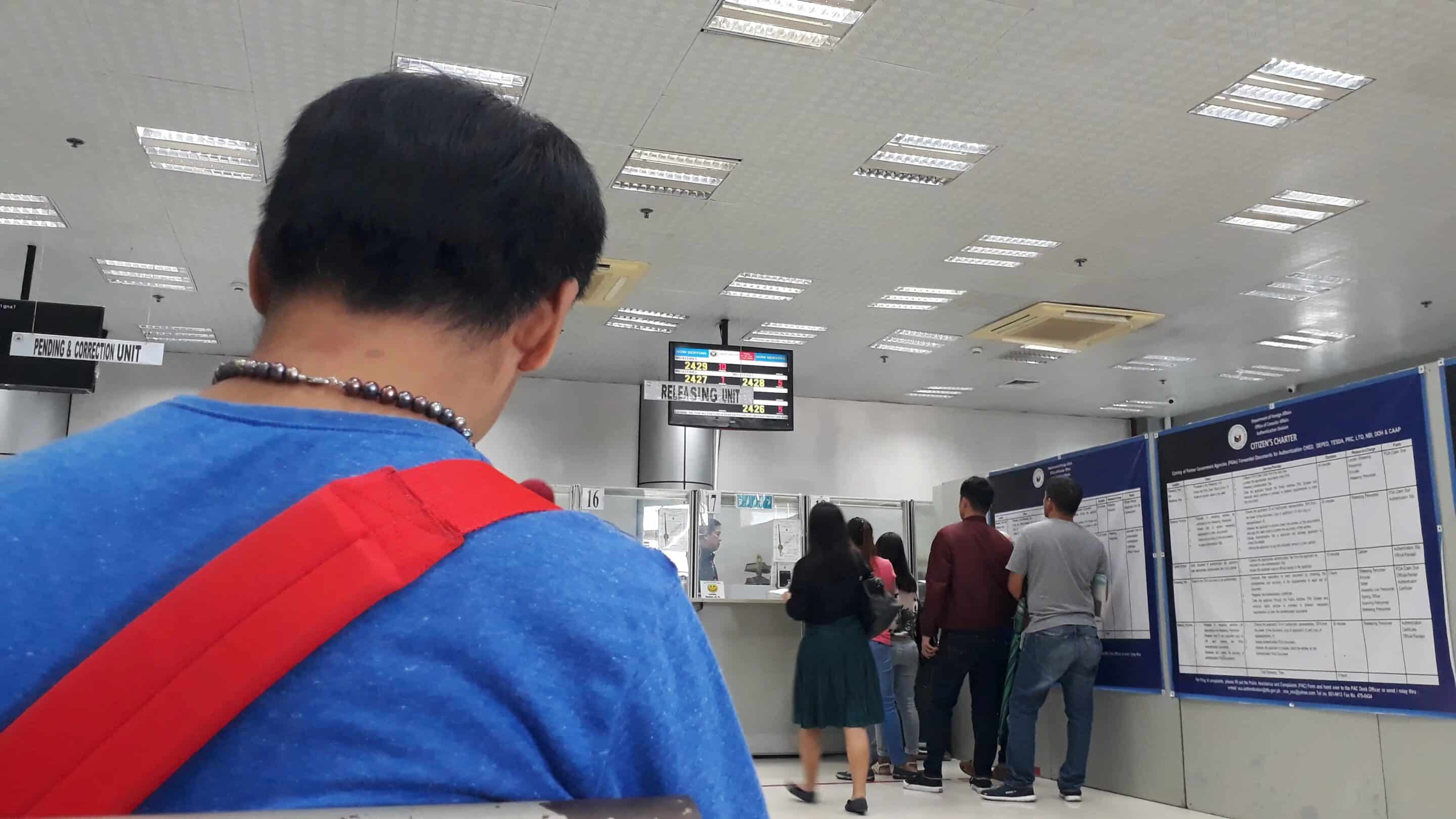 A photo of a man sat in a Department of Foreign Affairs waiting area, ready to collect his Apostilled documents