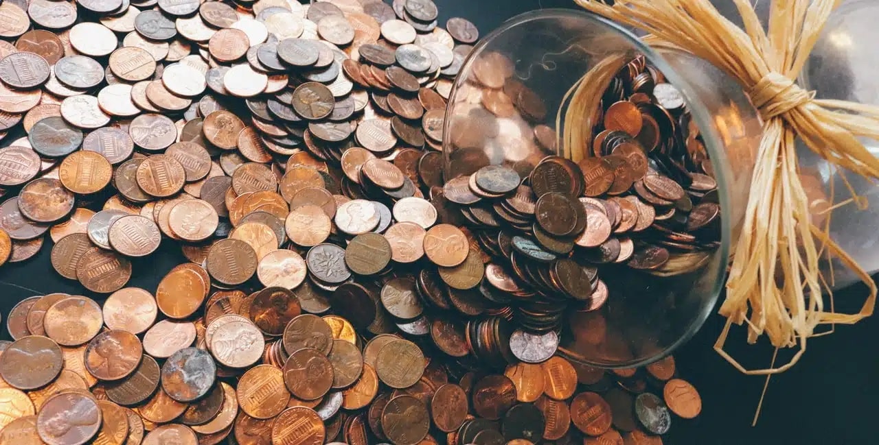 A jar on its side full of old coins and currency. A Separation case is often more expensive than an Annulment case