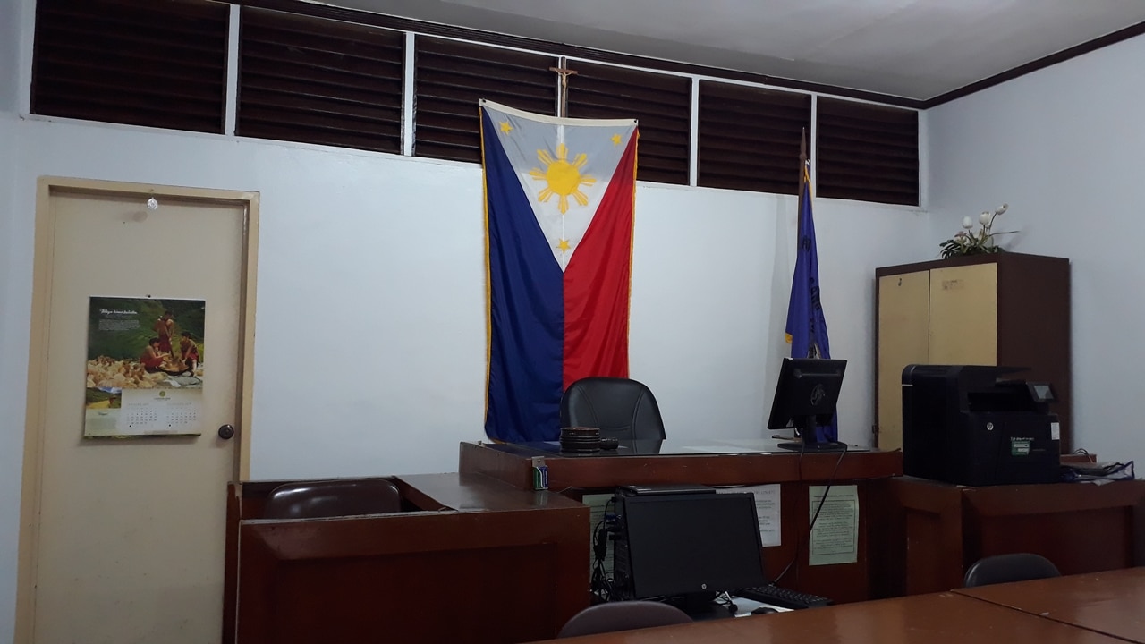 A photo of a Family Court in the Philippines where Annulment Cases will be heard. There Philippine flag is behind the Judges chair. How to file annulment in Philippines while abroad