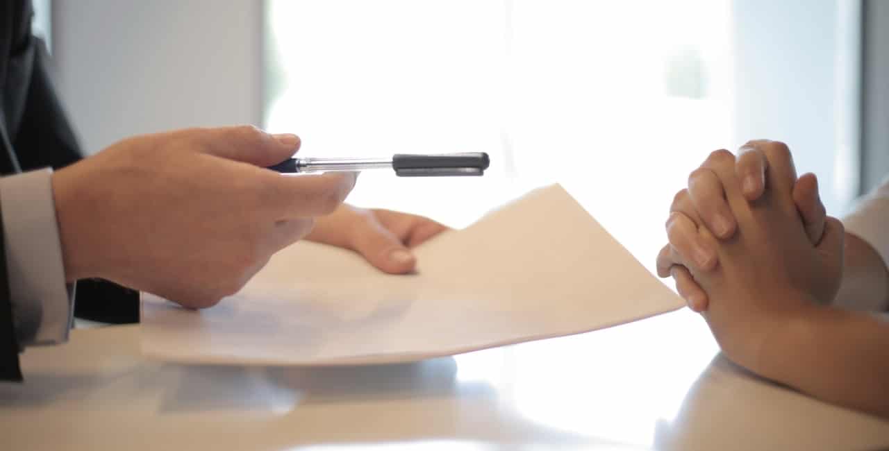 A photo of a lawyer and client interview. The lawyer is holding a pen and indicating to a piece of paper. What is the Annulment process in the Philippines without appearance?