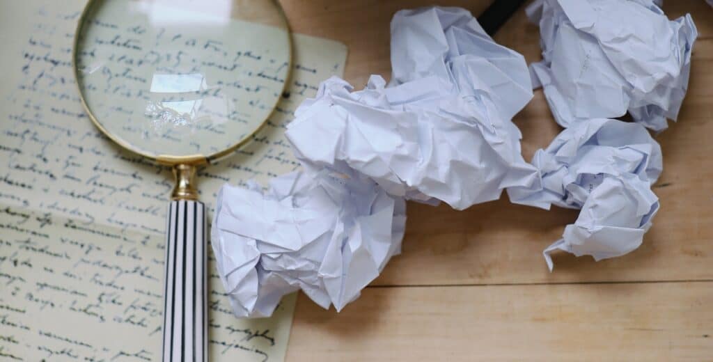 A magnifying glass for looking at the handwriting of a Last Will and Testament Philippines, with some crumpled papers to the right side.