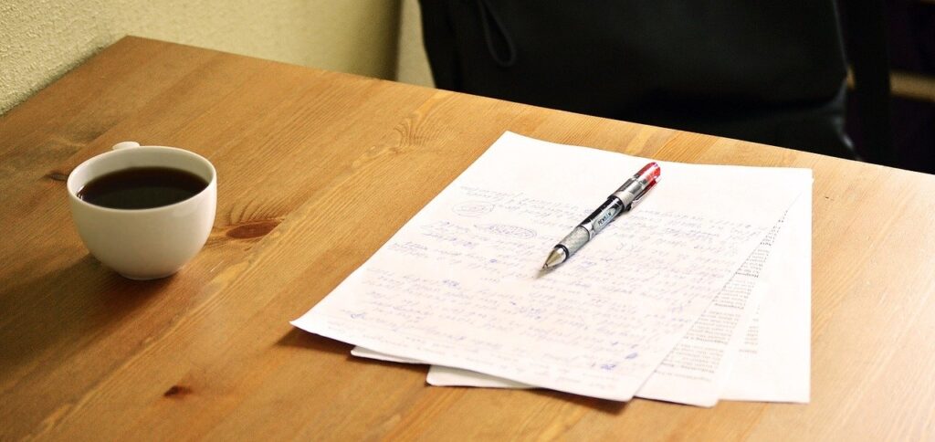 A wooden table with a cup of coffee on the left and a written Will and pen. Notarial Will Philippines has advantages over a Holographic Will Philippines