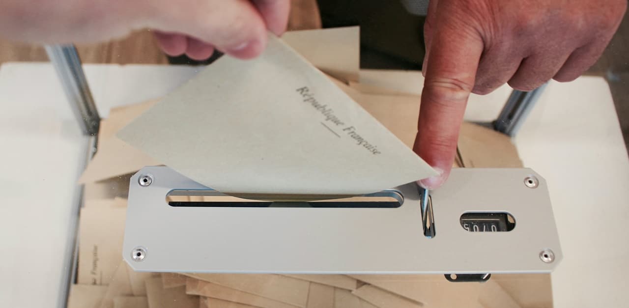 A person casting his vote through a dropbox
