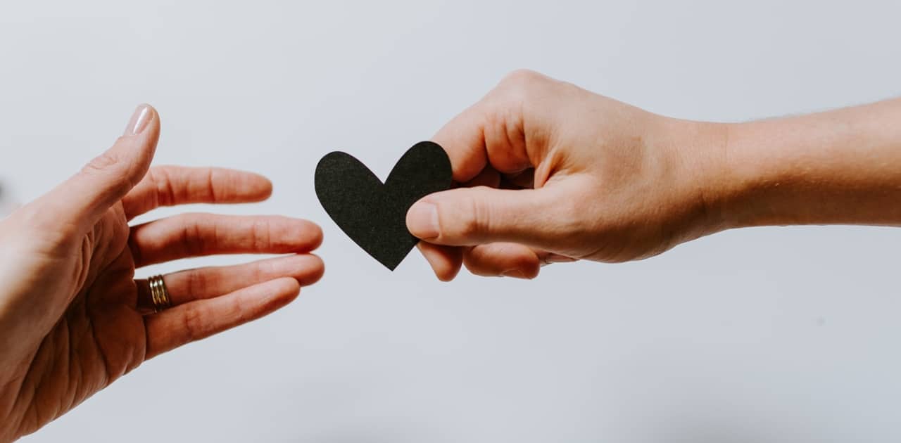 Handing a black heart to another person