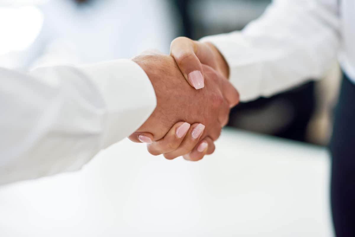 Caucasian businessman shaking hands with businesswoman in an office