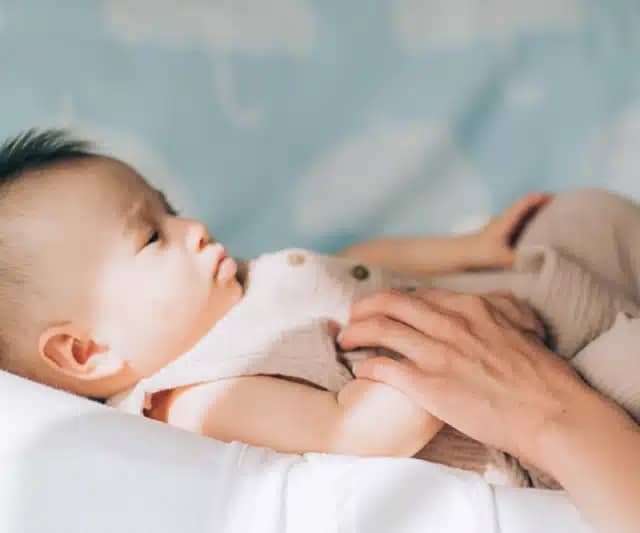 Child adoption and In Vitro Fertilization IVF . Asian child lying on the bed. Caring for newborn children