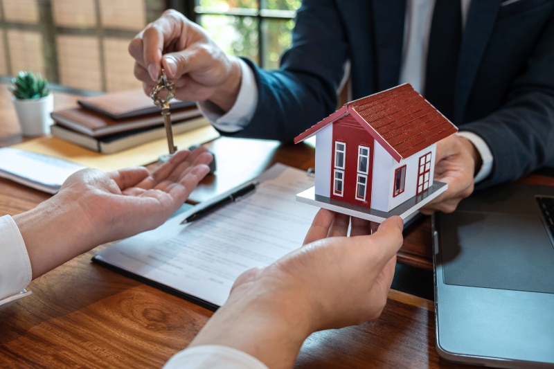 Real estate agent are presenting home loan and sending keys to customer after signing contract to buy house with approved property application form, Insurance Home concept