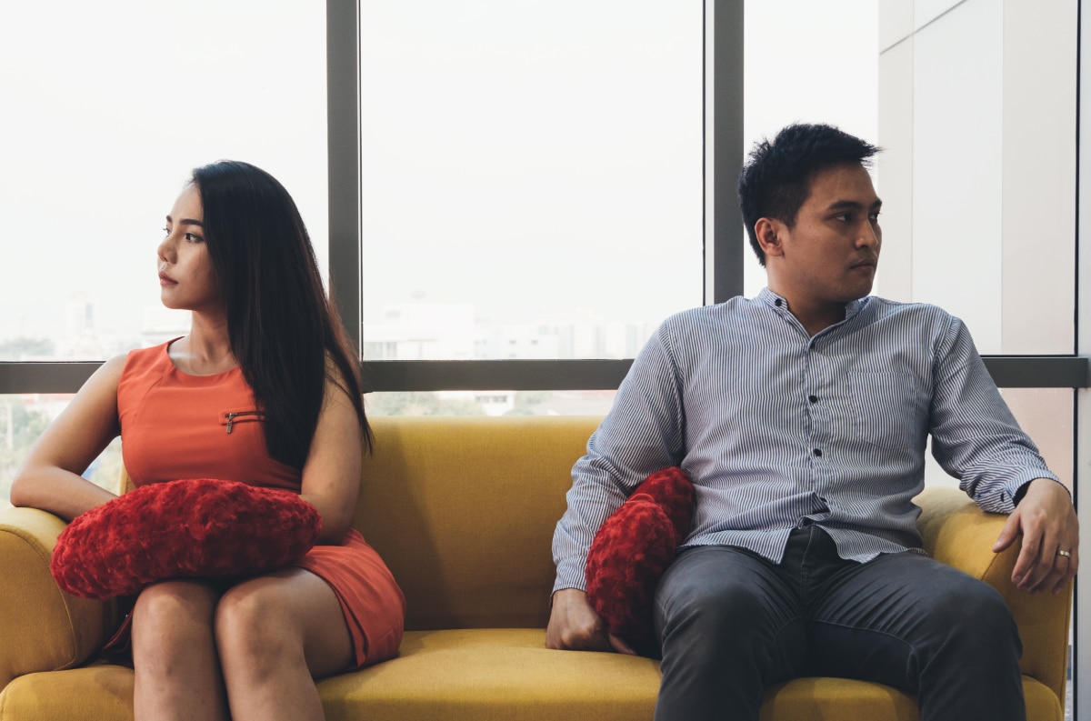 Unhappy couple feeling bad after argument on the couch