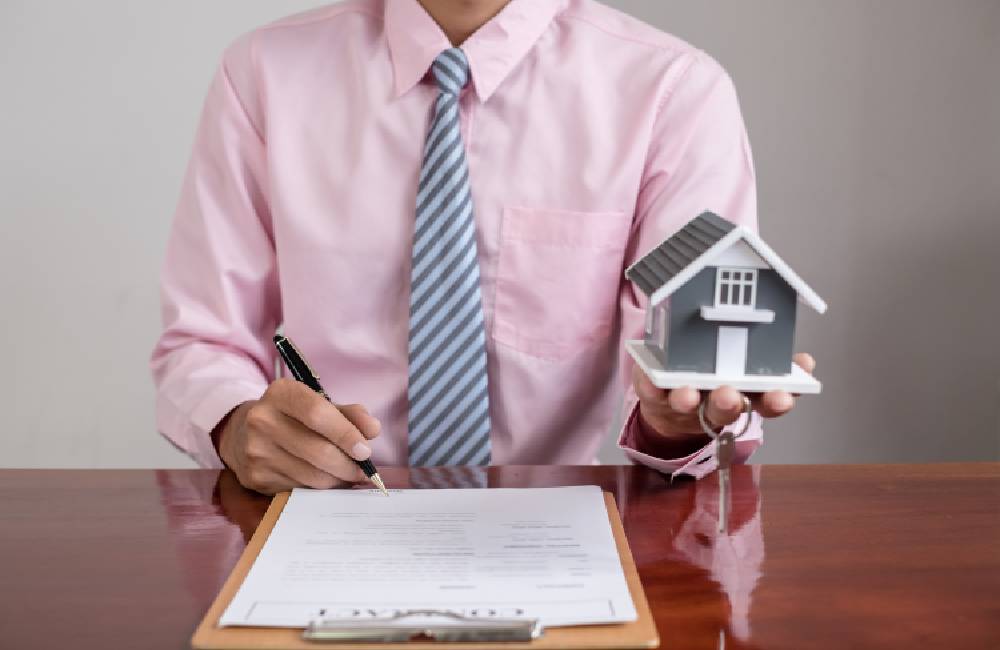 Photo of a man holding a model house up showing that an Extrajudicial Settlment transfers property to new owners, which can then profit from it.