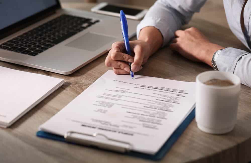 A man signing his will. An original Will is needed for presentation during the Probate case.