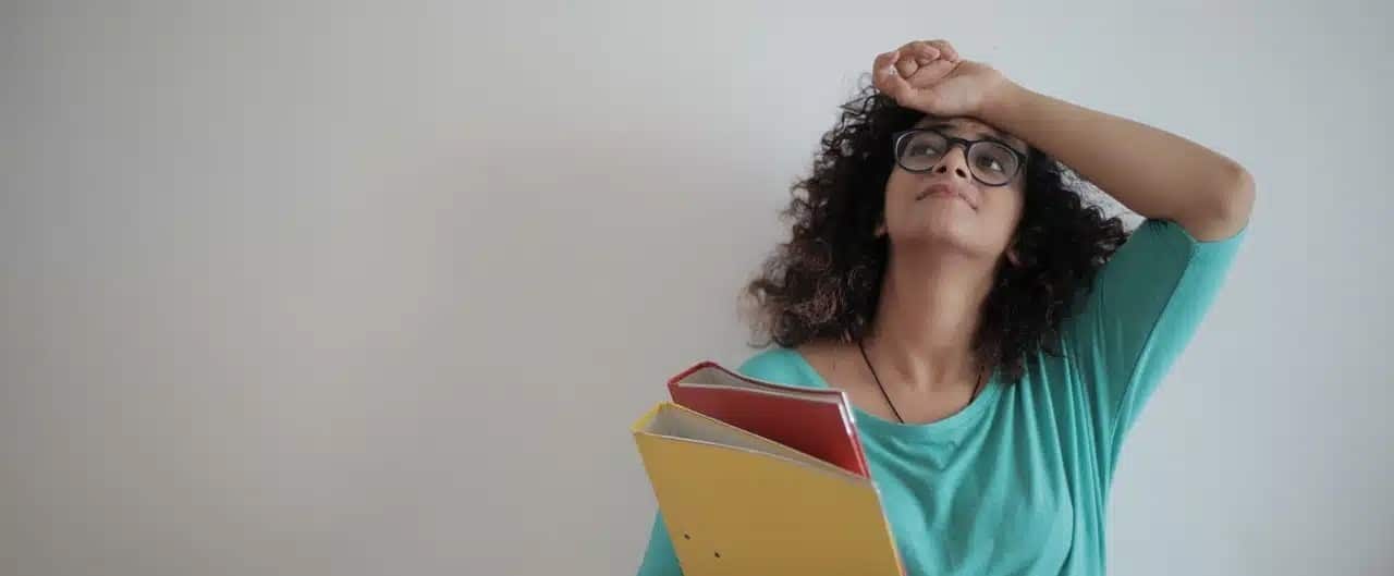 A woman holding documents while being stressed out