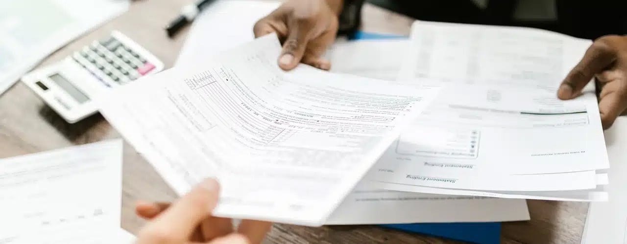 A man hands over a document to a woman