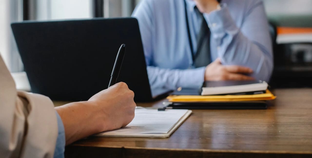 A person taking down notes during a meeting