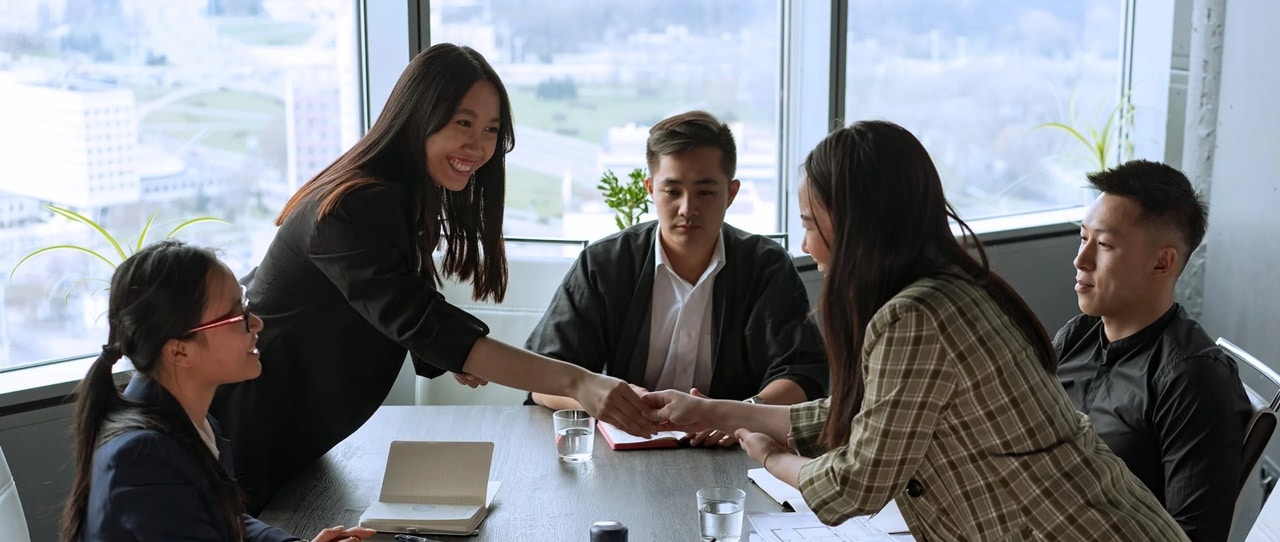 Two women shaking hands in a meeting