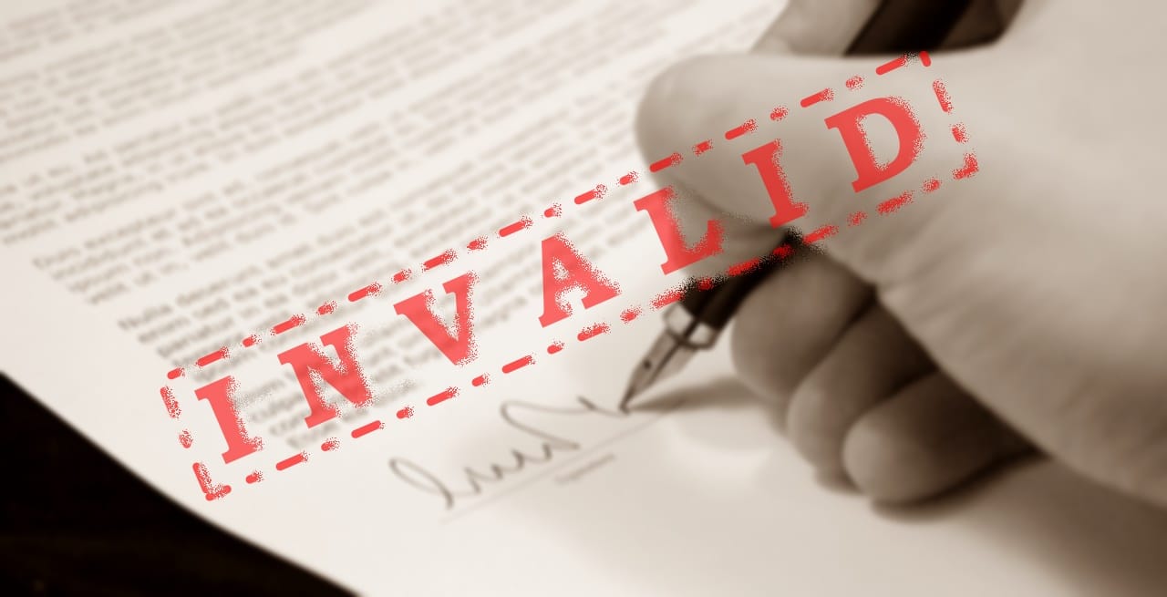 A picture of a person signing a document with INVALID stamp