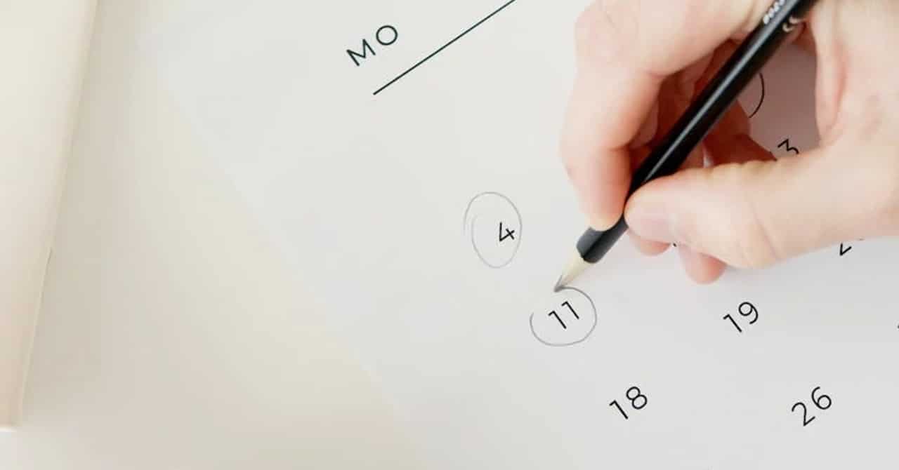 A hand marking a calendar date
