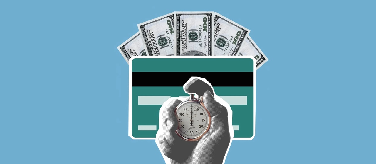 A hand holding a timer in front of dollar bills and a credit card