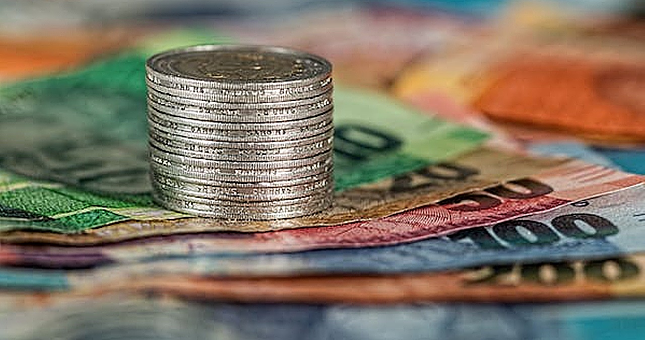 stack of Philippine peso coins over peso bills